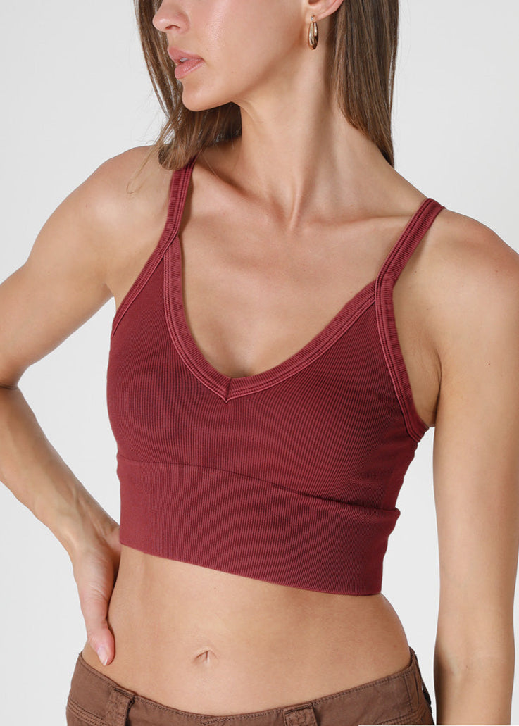Woman wearing a red crop top with a plain background